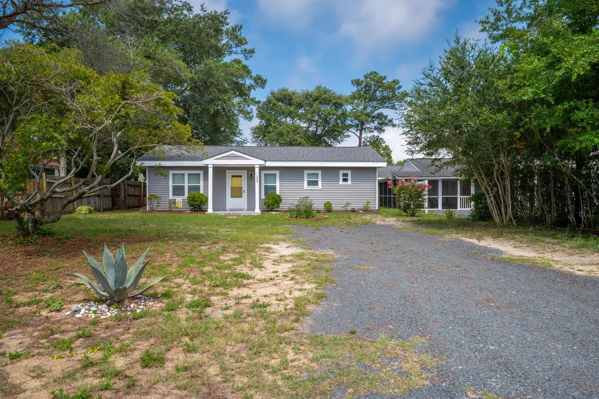 This image shows the bright yellow front door of Beach Break Bungalow, framed by an agave plant and lush greenery. The entry is level with the ground, and the cheerful door is easily accessible from the walkway. The open, welcoming scene creates a sense of hospitality and ease right at the threshold.
