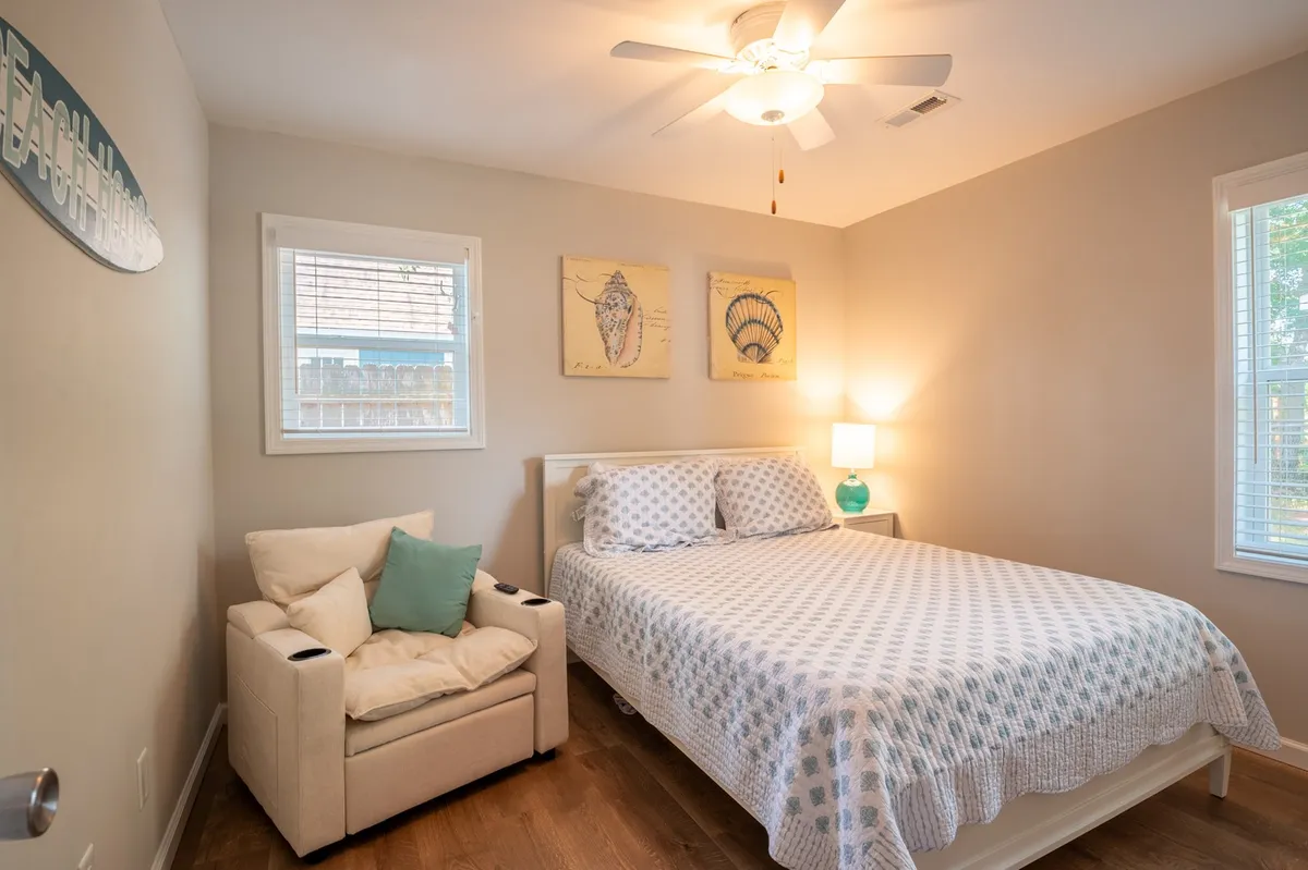 A peaceful bedroom with a cozy bed, a comfortable armchair, calming artwork, and a warm lamp provides a restful retreat. Natural light filters in, creating an inviting and intimate atmosphere perfect for couples unwinding after a day of exploration.
